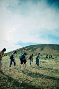 A group of hikers ascending a scenic hillside under a bright blue sky, perfect for adventure and travel themes.